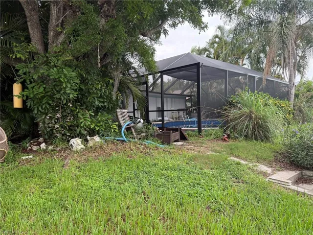 View of yard with an outdoor pool and glass enclosure