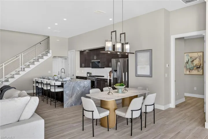 Dining area with stairway, wood finish floors, and recessed lighting