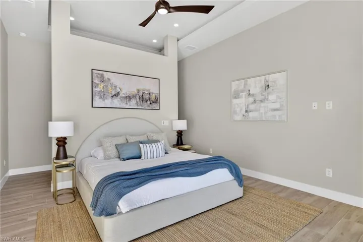 Bedroom featuring light wood finished floors, ceiling fan, and recessed lighting