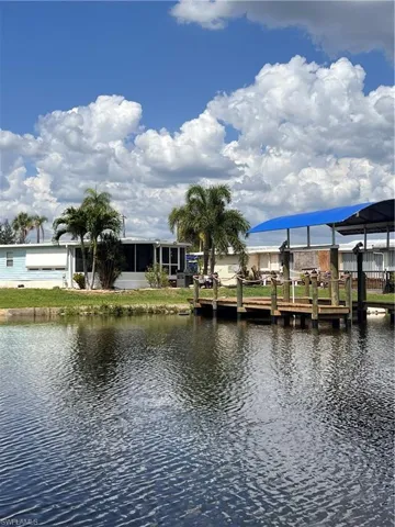 Dock featuring a water view and rear/side of home