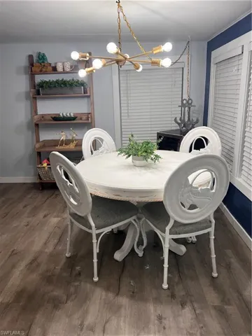 Dining room with a chandelier and laminate floors; windows have a water view