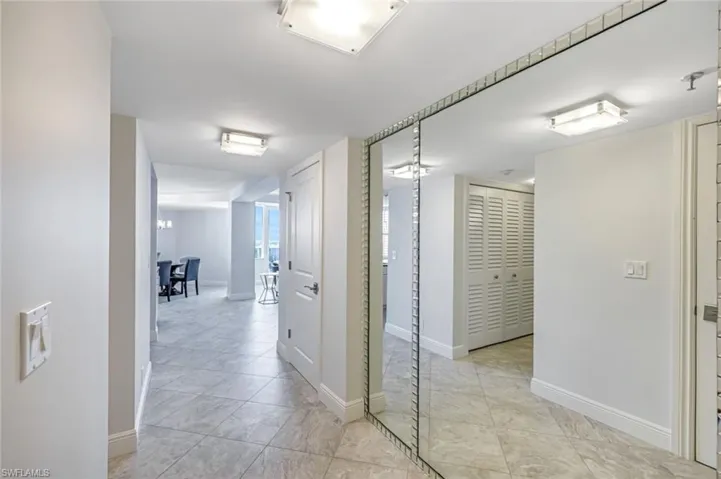 Hall with baseboards and light tile patterned floors