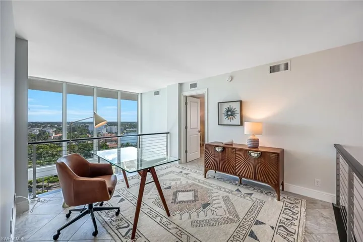 Home office featuring floor to ceiling windows and baseboards