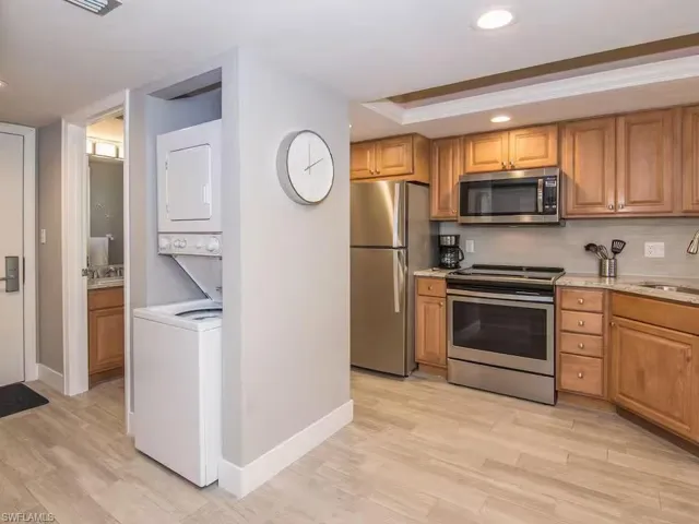 The kitchen features wood cabinetry, stainless steel appliances, and a light-colored countertop