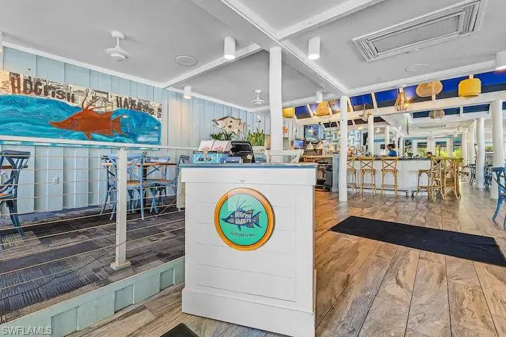Interior space featuring wood plank flooring, a white service counter, and a bar area with stools