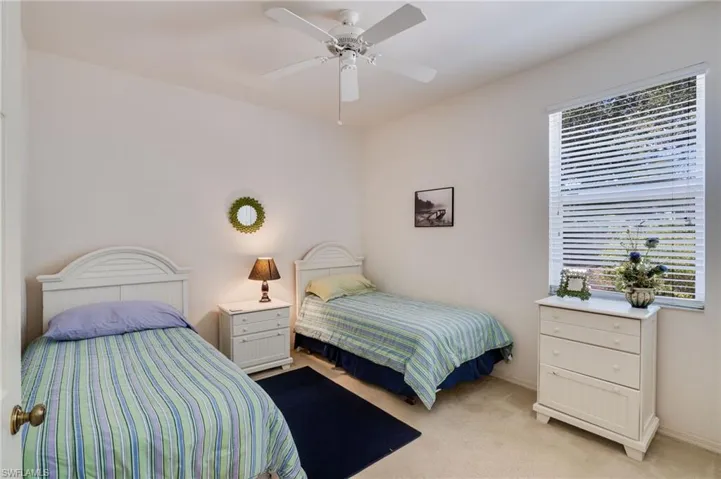 Carpeted bedroom featuring ceiling fan and baseboards