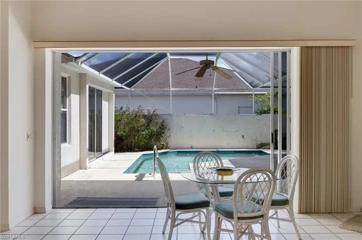 Outdoor pool with a patio area, a sunroom, and a lanai