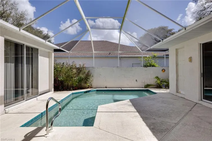 Outdoor pool with a patio, glass enclosure, and a sunroom