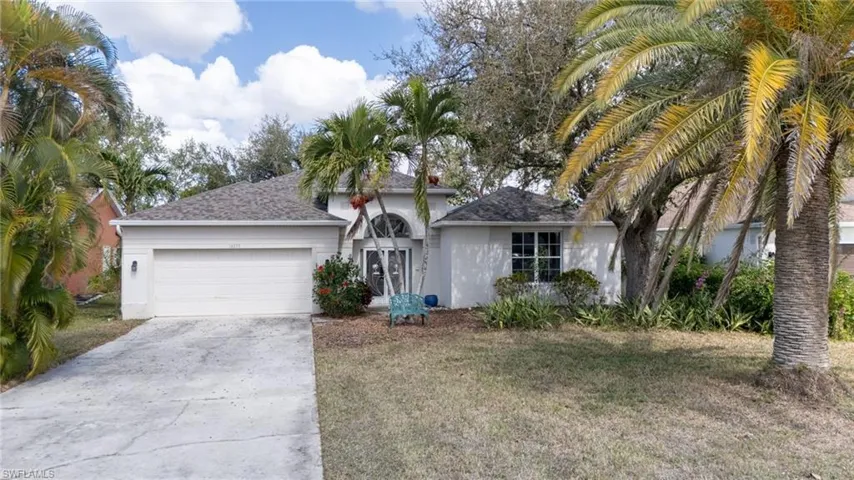Ranch-style house featuring stucco siding, an attached garage, driveway, a front lawn, and a shingled roof