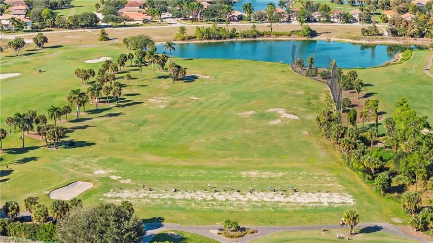 Aerial view of residential area featuring a local golf course and a large body of water