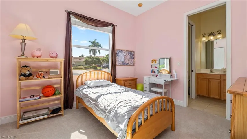 Bedroom featuring light colored carpet and connected bathroom