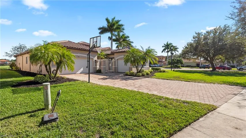 View of home's exterior featuring decorative driveway, a yard, stucco siding, and a tile roof