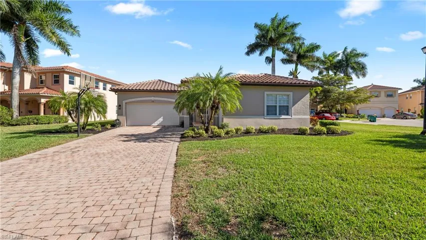 Mediterranean / spanish-style house with stucco siding, decorative driveway, a tile roof, and a front yard