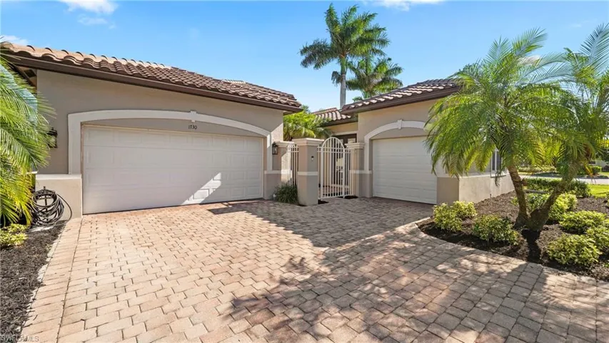 Garage featuring a gate and decorative driveway