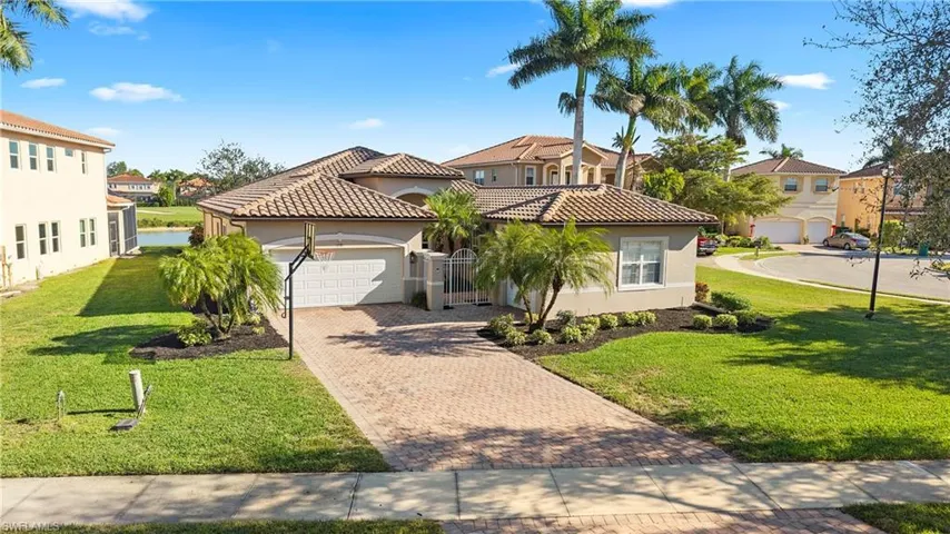 Mediterranean / spanish home featuring stucco siding, a front lawn, decorative driveway, and an attached garage
