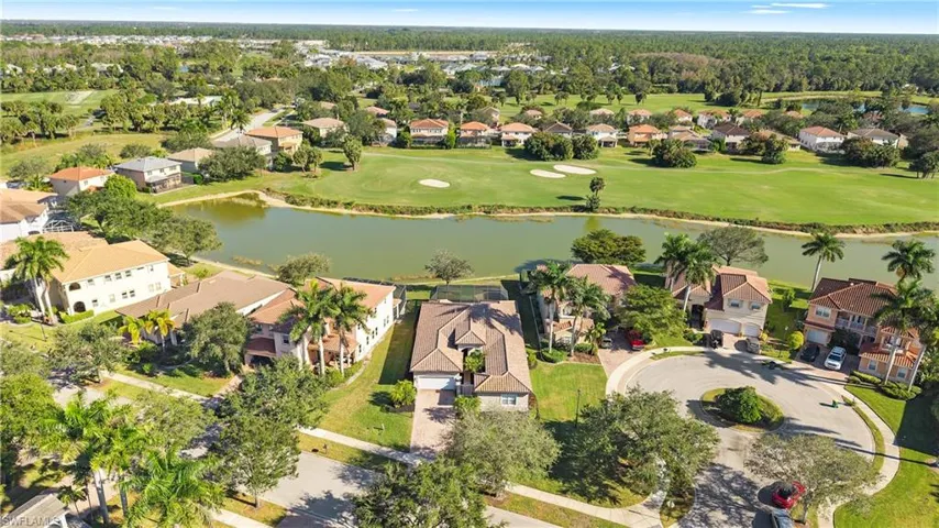 Aerial perspective of suburban area with a large body of water and a golf course