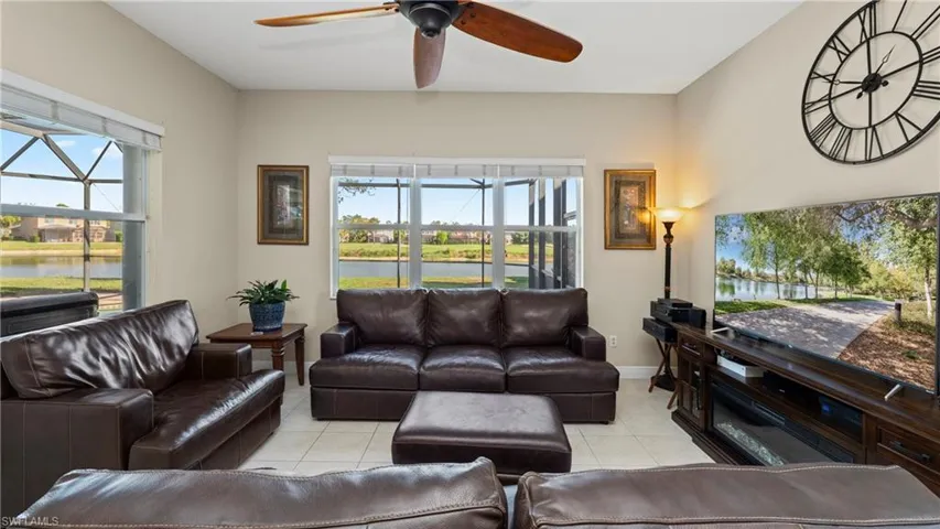 Living area with light tile patterned flooring, a water view, and plenty of natural light