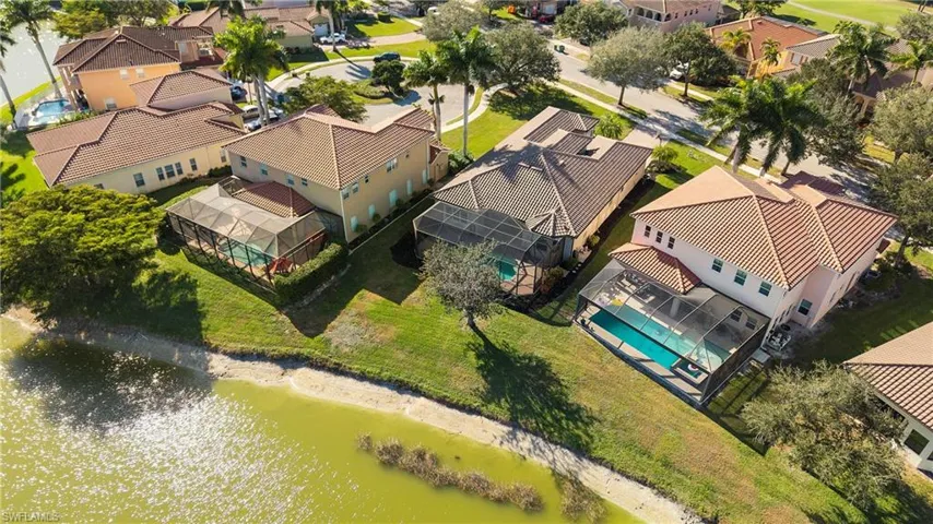 Aerial view of residential area with a pool and a large body of water