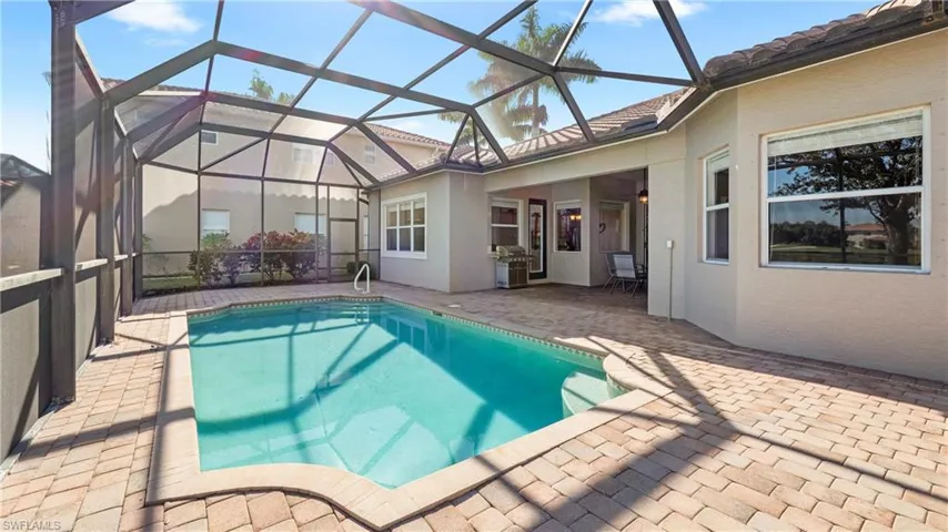 Swimming pool with a sunroom, a patio, a lanai, and grilling area