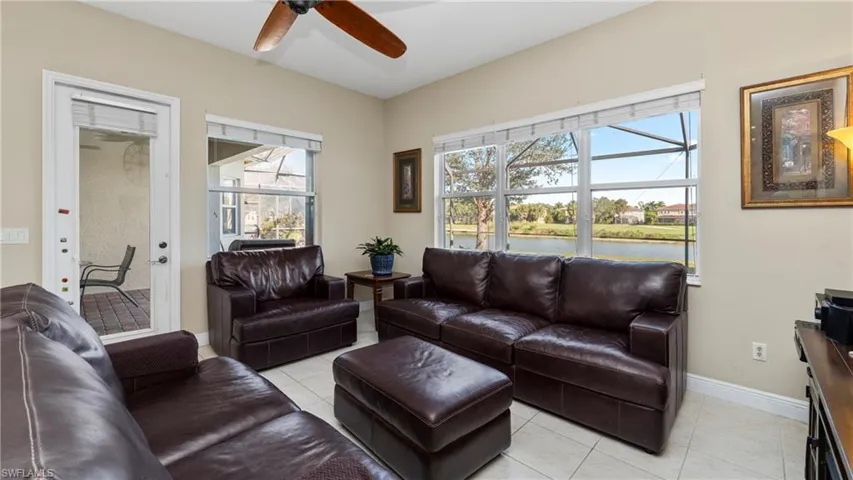 Living area featuring light tile patterned floors, a water view, and ceiling fan