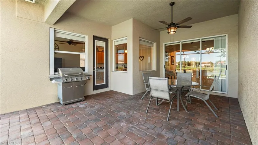 View of patio with grilling area, ceiling fan, and outdoor dining space