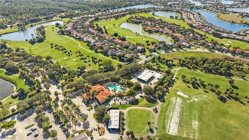 Aerial view of property and surrounding area with a local golf course and a nearby body of water