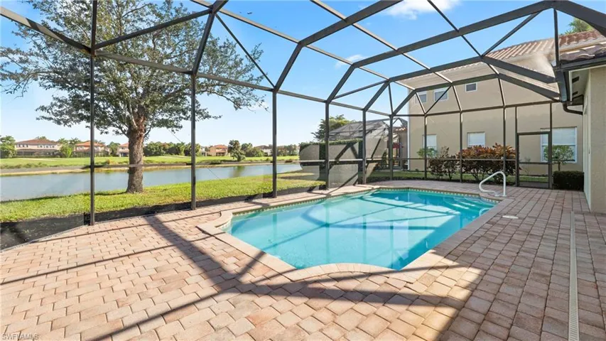 Swimming pool with a lanai, a water view, a sunroom, and a patio