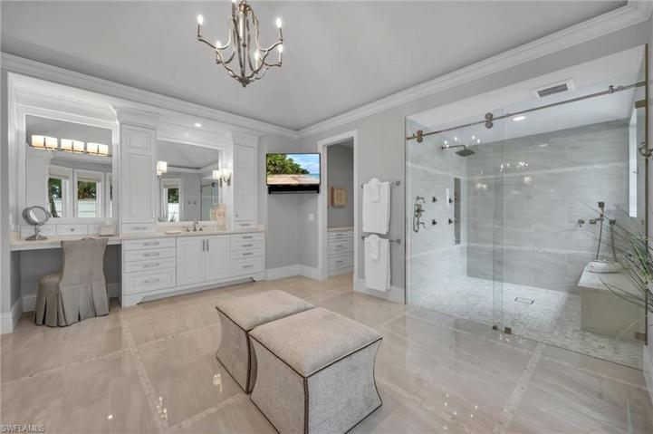 The shower is equipped with large, rain shower head, polished nickel fixtures and gorgeous inlaid tile work. Even the water closet has custom cabinetry for added storage space.