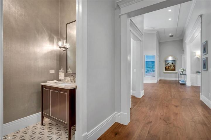 The exquisite guest powder room has details such as inlaid marble floors, gorgeous luxe wallpaper, and modern, crystal sconces.  Even this powder room was well thought-out.