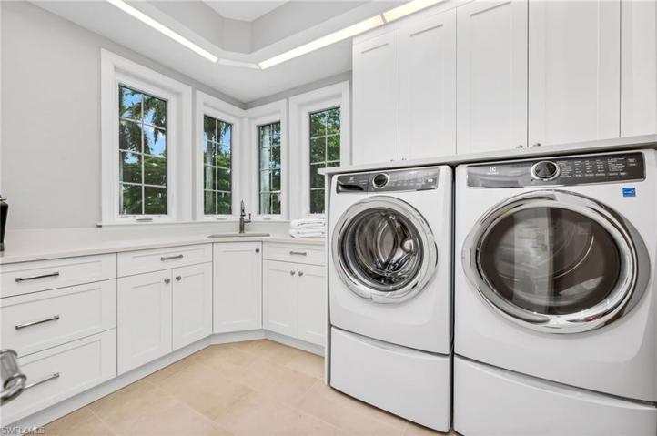 The laundry room is huge, with a long hallway for storage.  New cabinetry with polished nickel hardware, impact windows, and large-capacity washer and dryer.  This is not your basic laundry room!