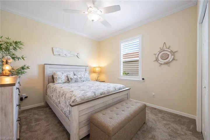 New carpeted 2nd bedroom featuring crown molding, a closet, plantation shutters, and ceiling fan