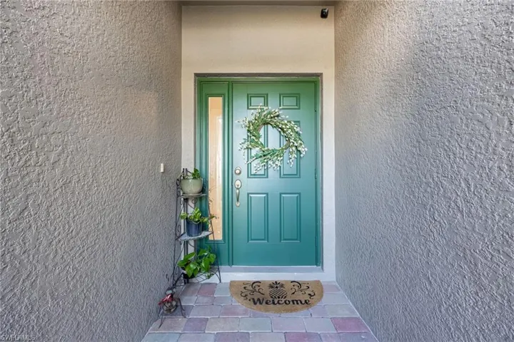 Welcoming front door and sidelight once inside screened entry.