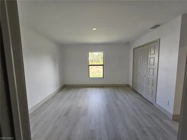 Unfurnished bedroom featuring light wood-style floors and a closet