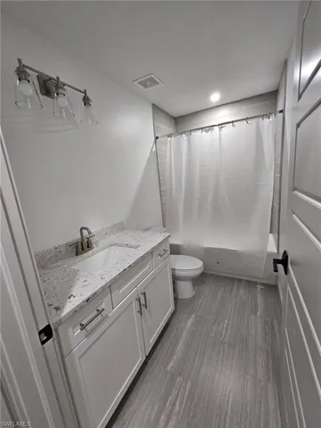 Full bathroom with shower / tub combo and vanity