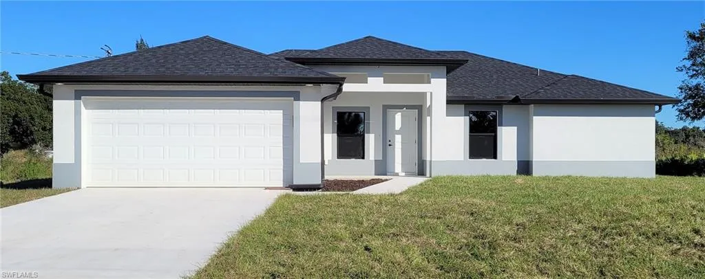 View of front of home featuring a garage and a front yard