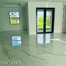 Empty room featuring french doors and marble finish floors