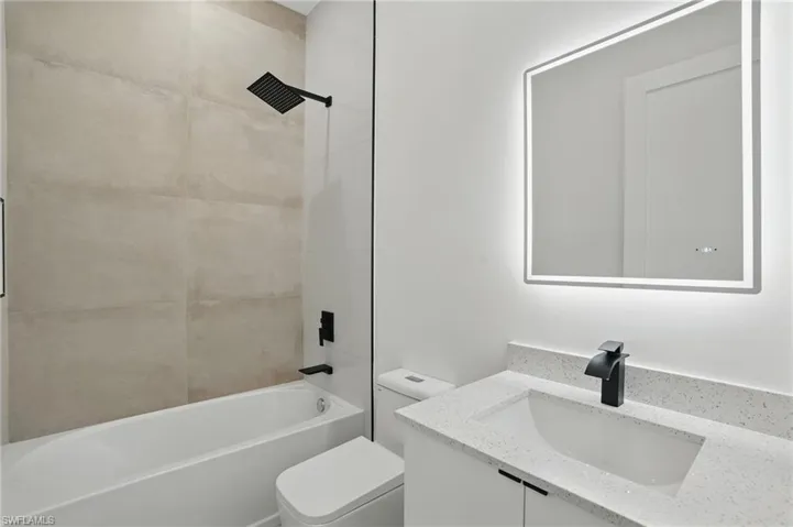 Full bath with toilet, vanity, and washtub / shower combination
