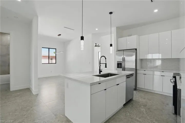 Kitchen featuring a sink, dishwasher, modern cabinets, white cabinetry, and recessed lighting