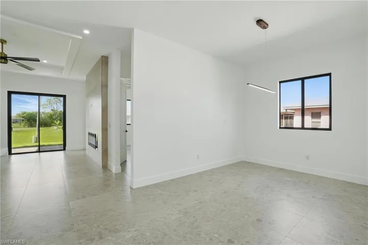 Empty room with baseboards, recessed lighting, a ceiling fan, and a tray ceiling
