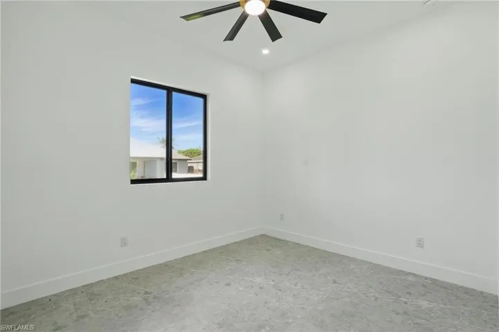 Carpeted empty room with baseboards and a ceiling fan