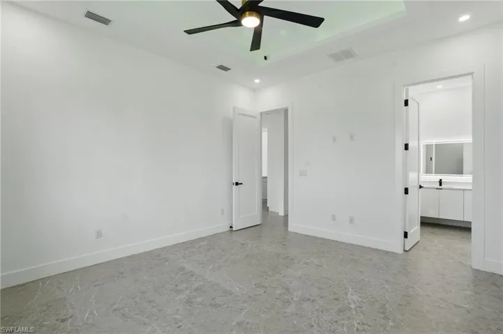Unfurnished bedroom with recessed lighting, baseboards, a tray ceiling, and ceiling fan