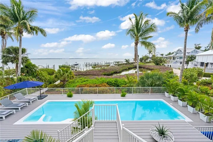 View of pool with patio surround and a water view