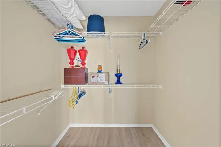 Built-in wire shelving system with multiple storage levels, neutral painted walls, and wood-finish flooring
