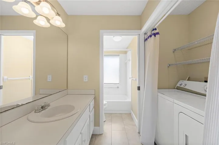 Vanity area with a built-in sink, expansive mirror, and overhead light fixture