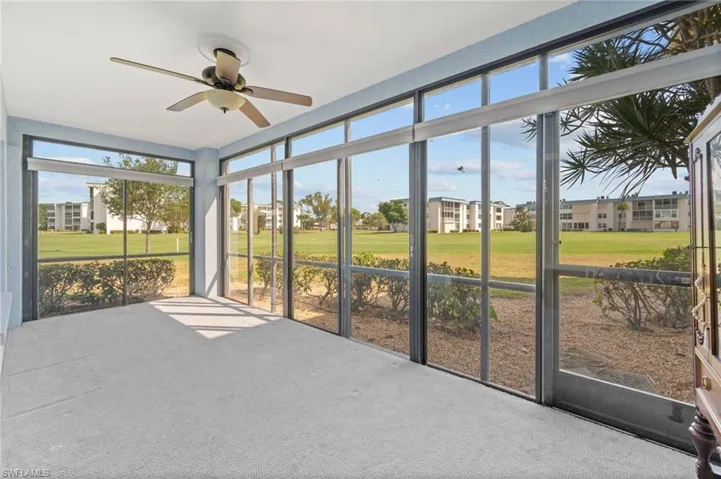 Expansive screened enclosure with light blue walls and a ceiling fan fixture