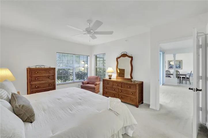 Carpeted bedroom with a ceiling fan and baseboards