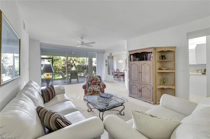 Living area featuring light colored carpet and ceiling fan