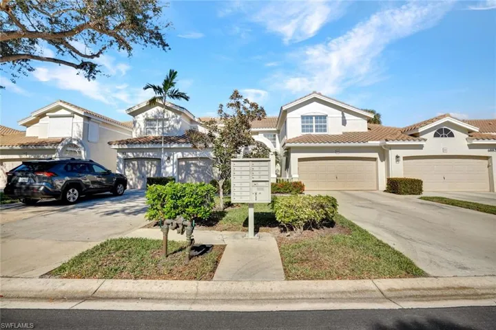 View of front of property with driveway, a tiled roof, stucco siding, and a garage