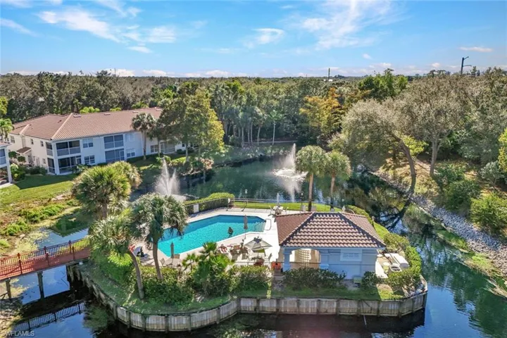 Aerial view of property and surrounding area featuring a large body of water and a pool area