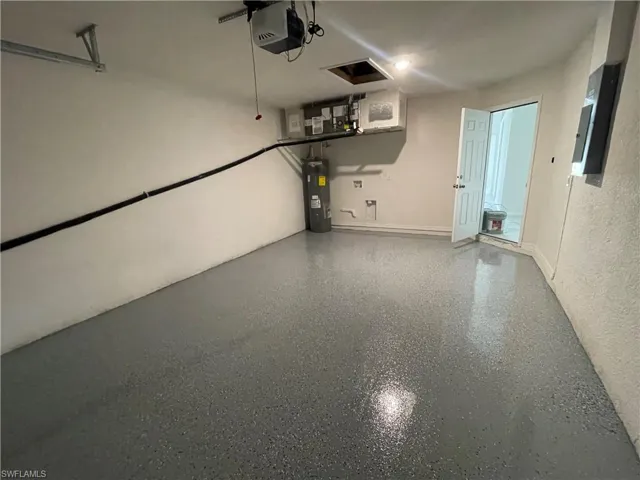 Garage featuring water heater and a garage door opener